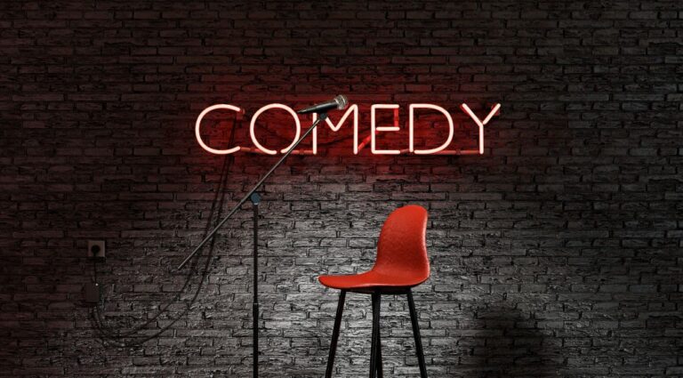 stand up comedy stage illuminated by spotlight with word comedy red neon lamp 1024x566 1