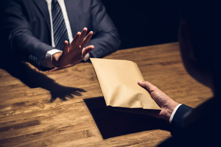 businessman rejecting money envelope