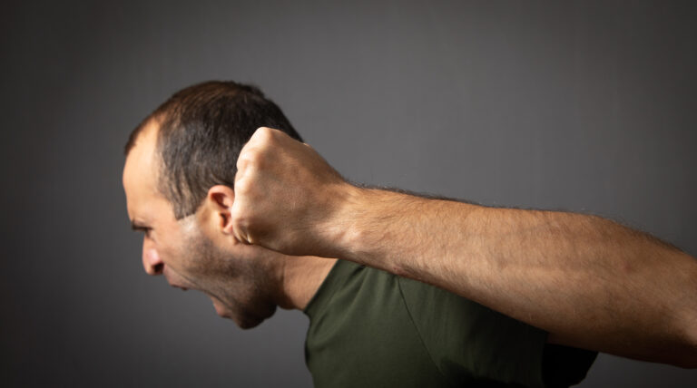 angry young man shouting threatening with fist
